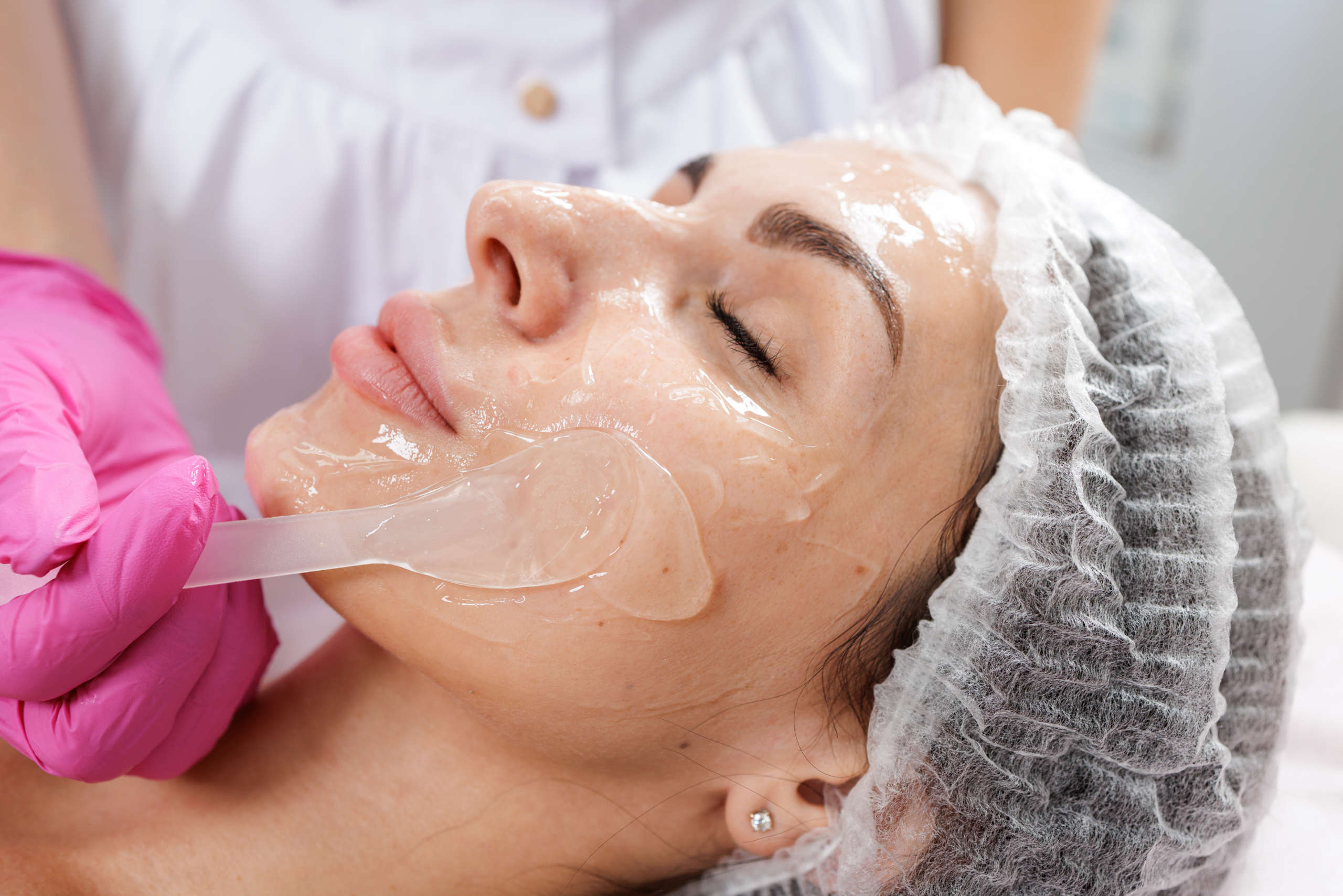 closeup hydrogel facial mask application during professional skincare treatment